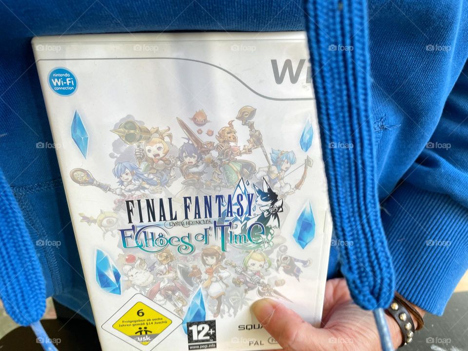 A hand holding the video game Final Fantasy 