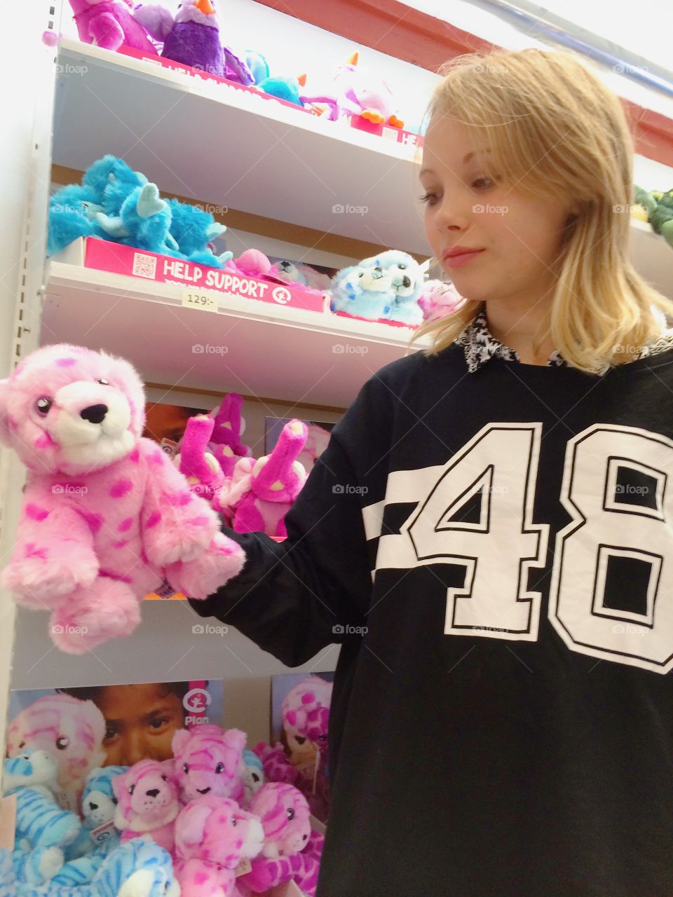 Shopping. Girl looks at some soft toys