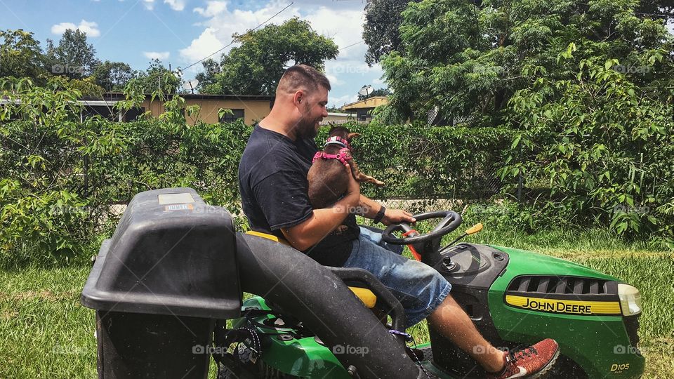Husband taking our pup for a ride on the big green mower! 