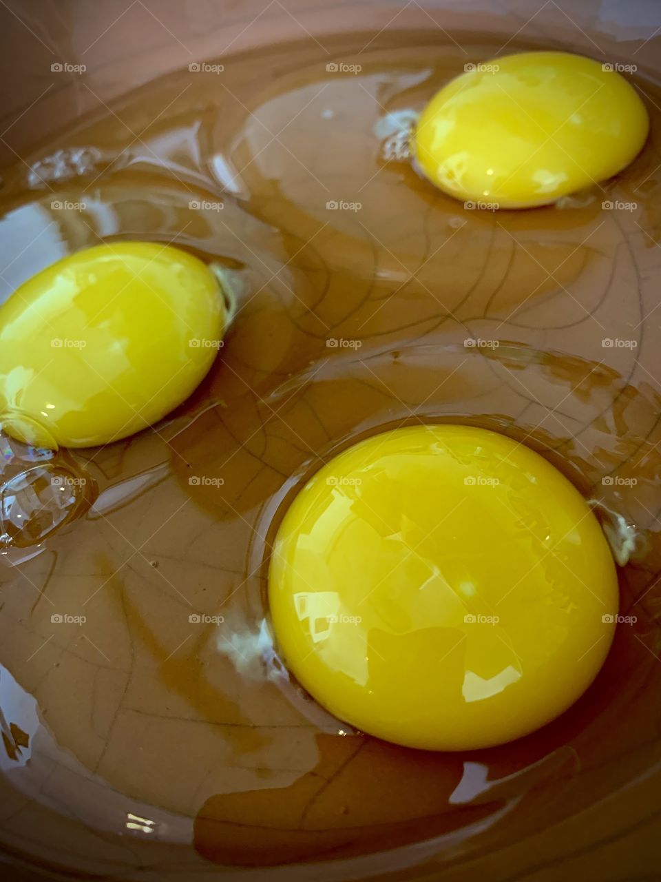 Three raw egg yokes in a bowl