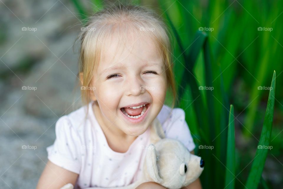 Candid portrait of happy little Caucasian girl with smiley face outdoor