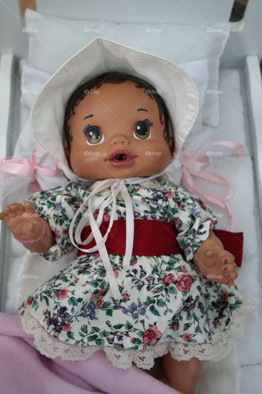 An old-fashioned Victorian doll in her crib