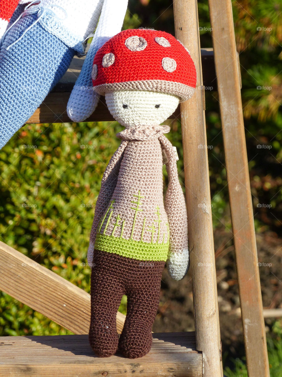 Crochet toadstool doll. A handmade crochet toadstool doll displayed on a vintage wooden stepladder