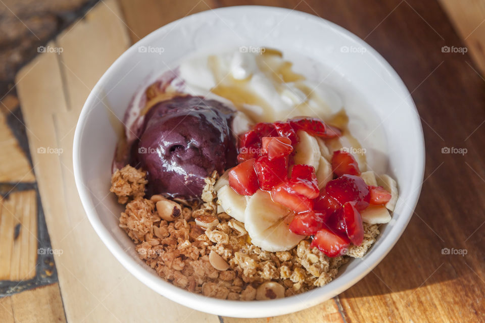 Healthy acai bowl with plain yogurt, fruits and granola