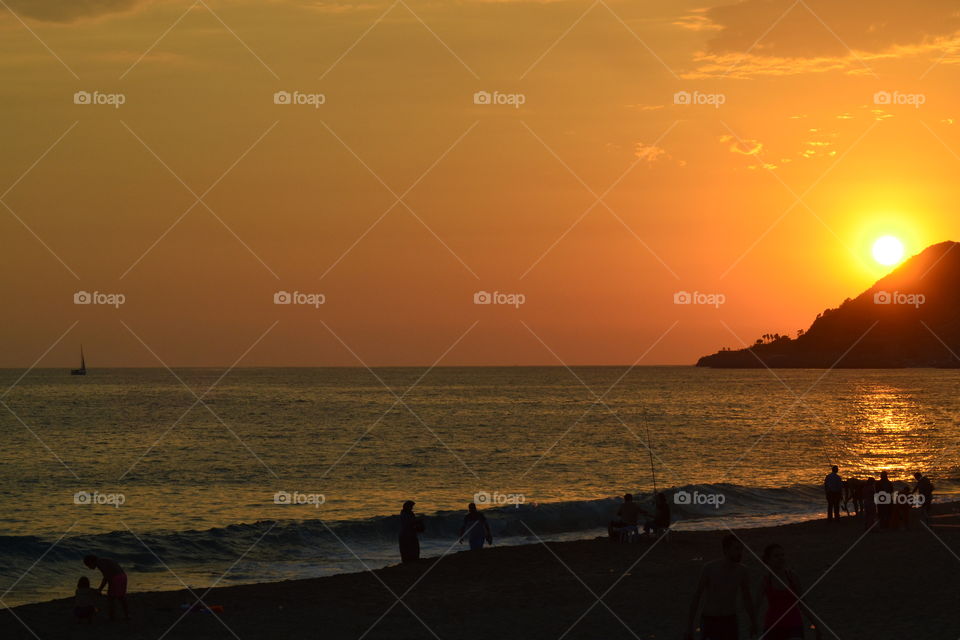 sunset in Alanya turkey over fishermen on the beach.