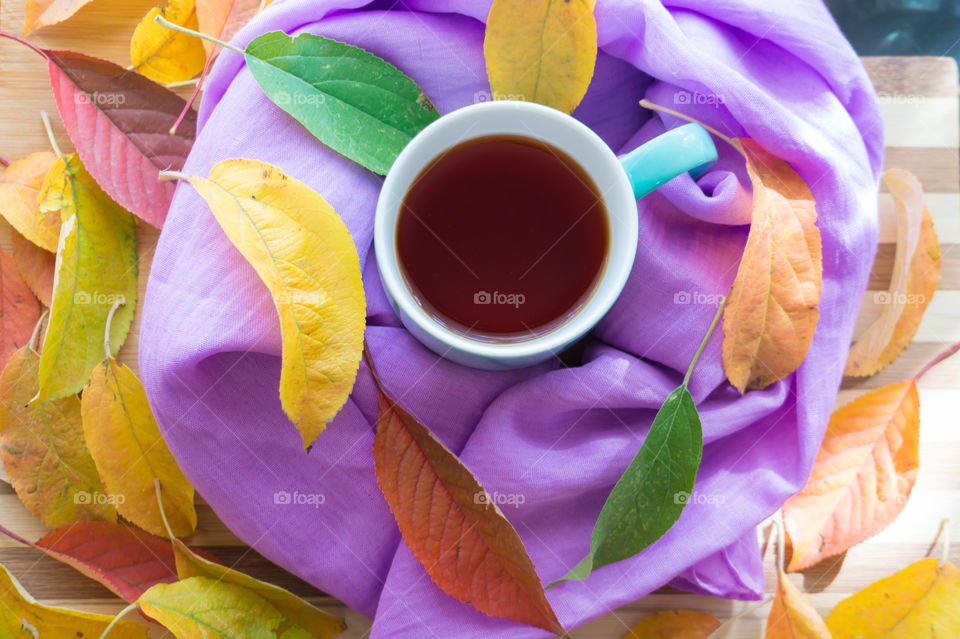 Hot flower tea in a blue mug on a wooden background