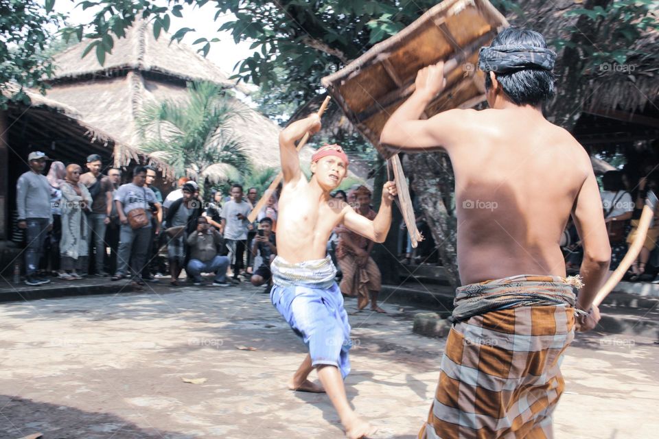 a fight between two men with traditional styles and weapons.