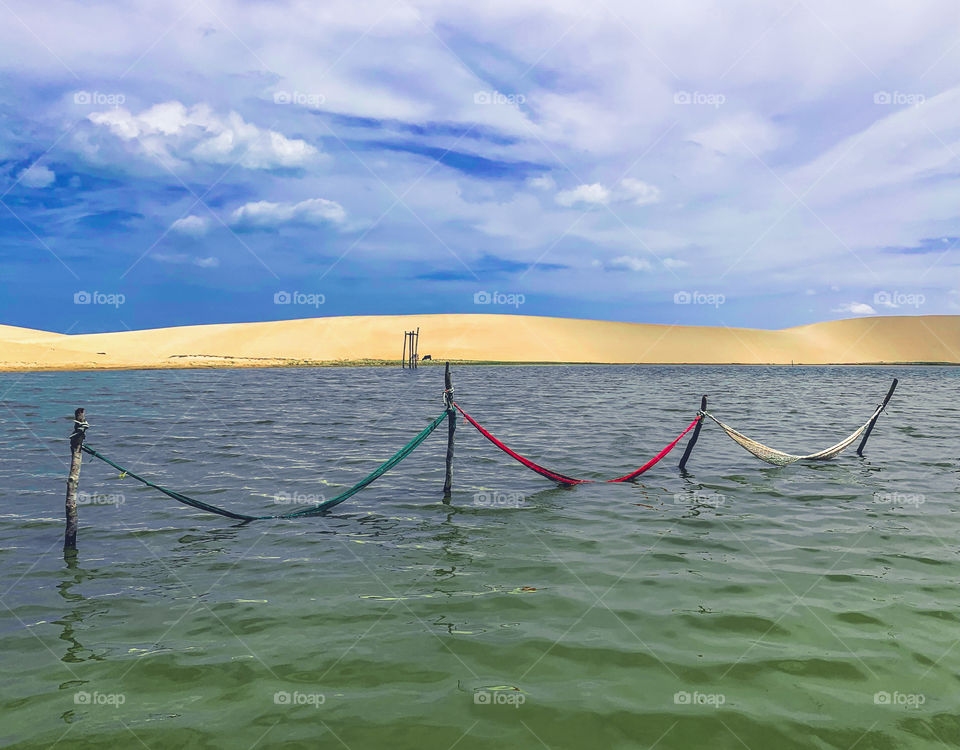 Three hammock in the water lake against dunes 