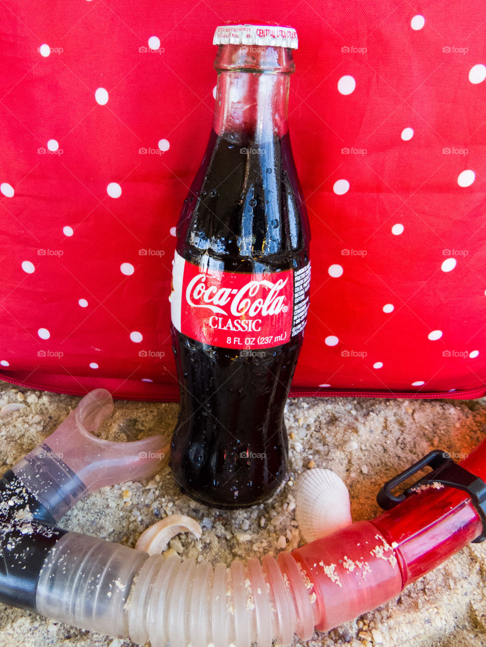 Classic Coca-Cola bottle at the beach with snorkel and red polka dot background.