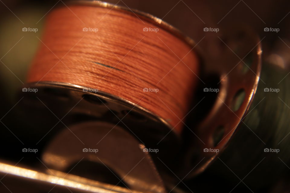 Orange metal thread bobbin close-up