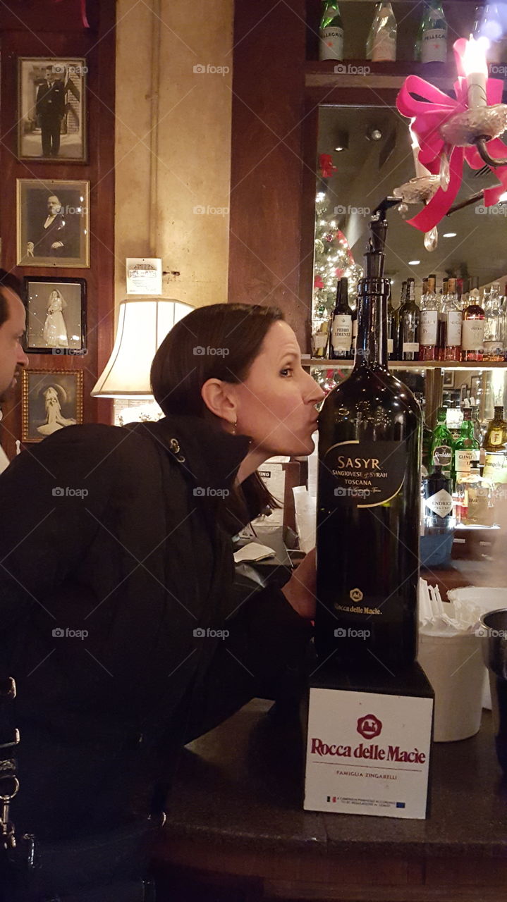 woman kissing wine bottle