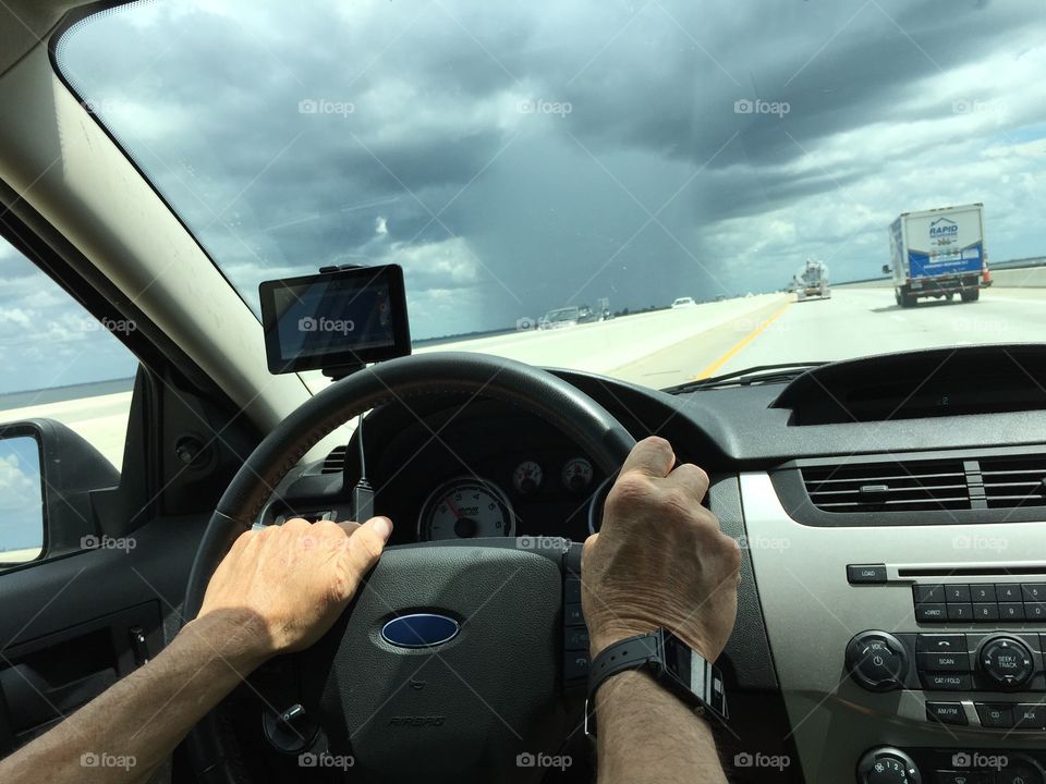 Driving on a bridge with a huge rainstorm ahead.