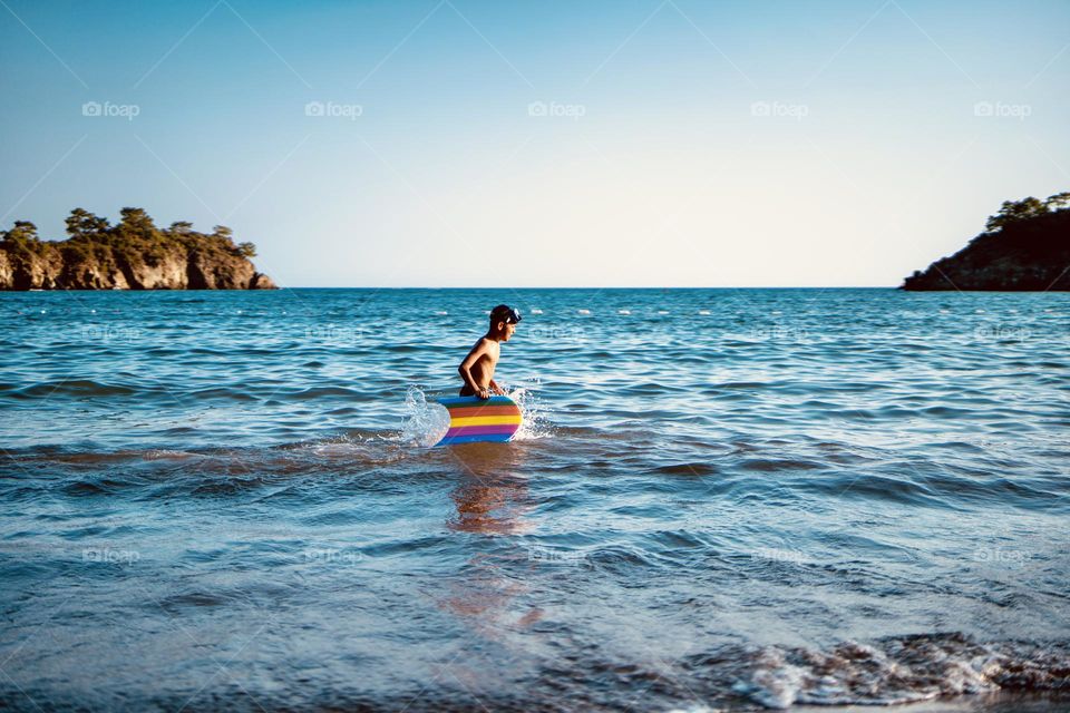 Child holding rainbow surf