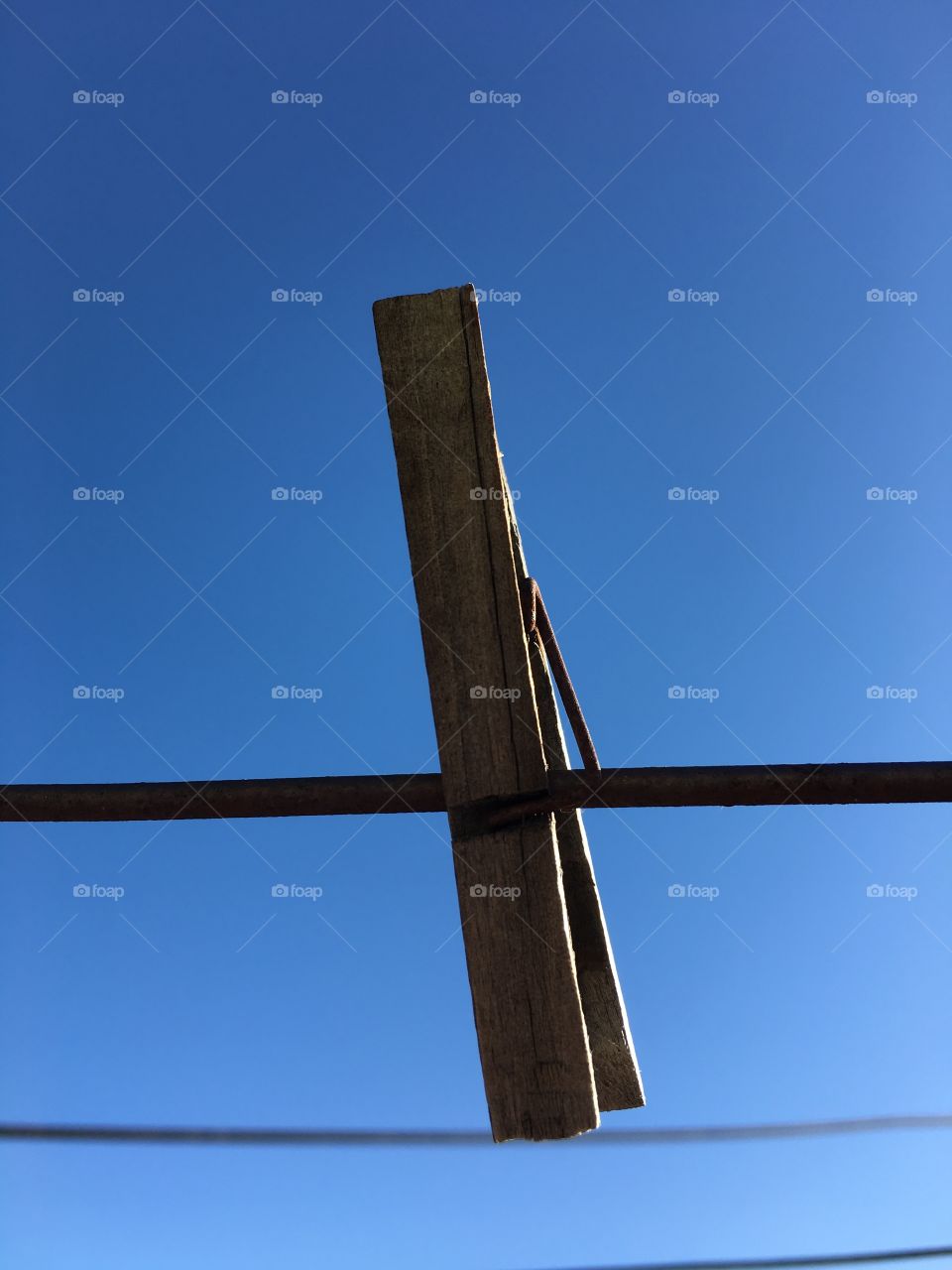 Almost silhouette one lone wood clothespin against an indigo sky conceptual minimalistic 