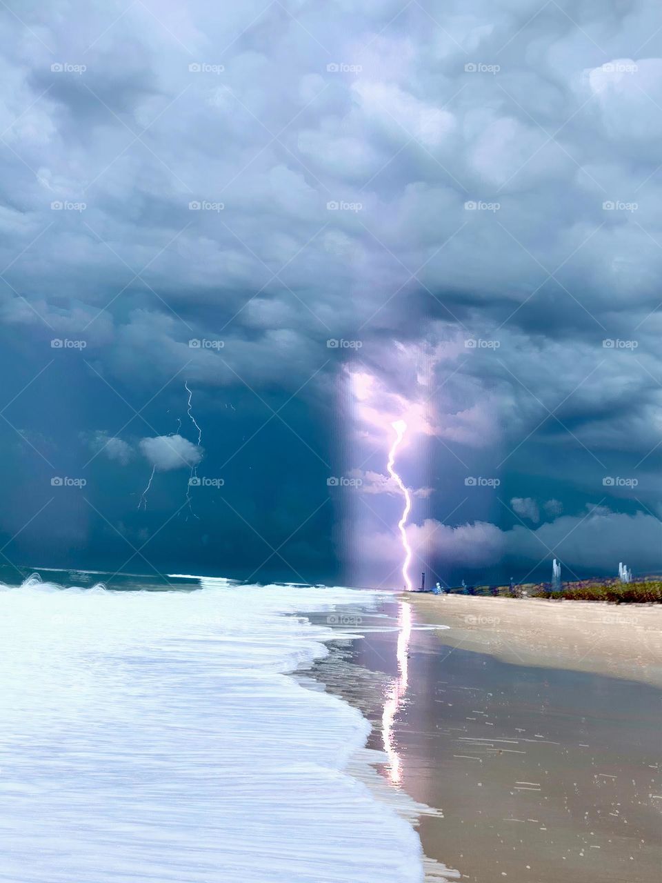 Atlantic Ocean Beach With Time In Motion Long Exposure Of The Waves On The Seashore And Lightnings During A Thunderstorm With Dark Grey Clouds.