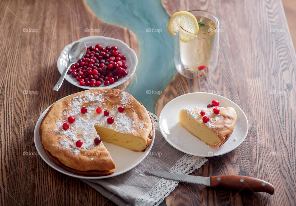 Cheesecake with cranberries and sugar on wooden background