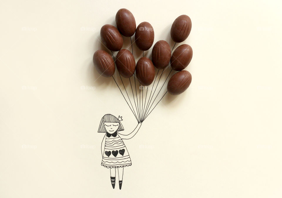 Drawing of a girl holding balloons of real chocolate eggs