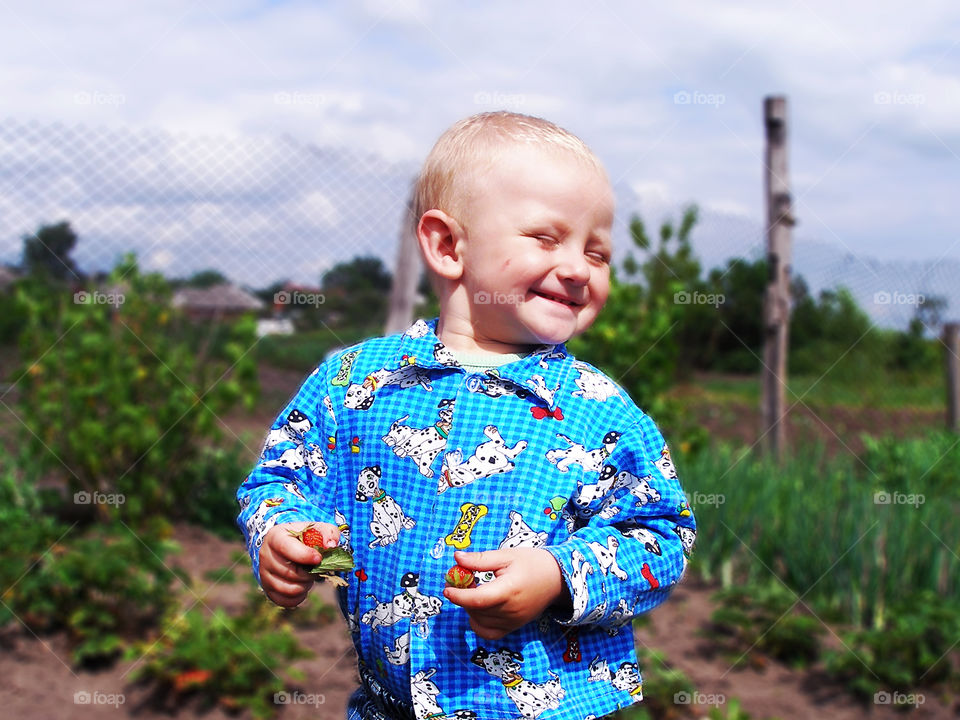 Child found two strawberries in the garden 