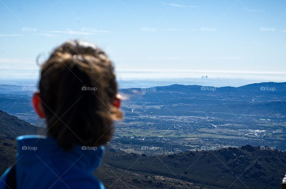Young girl looking at the view of Madrid from the mountain 