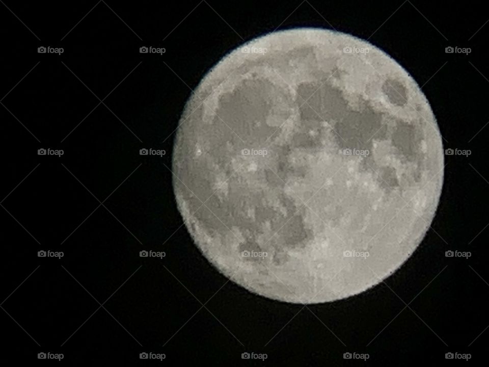 Beautiful full moon. The moon is round with black background. Night photography.