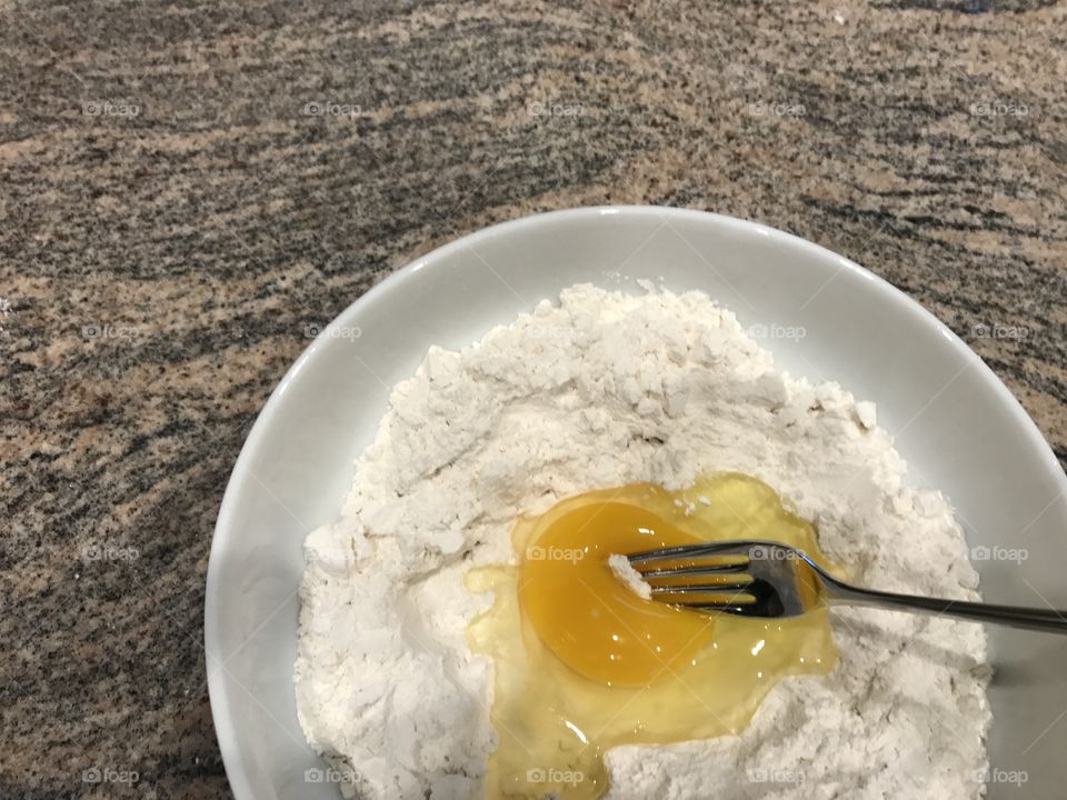 Bowl with eggs, flour and fork