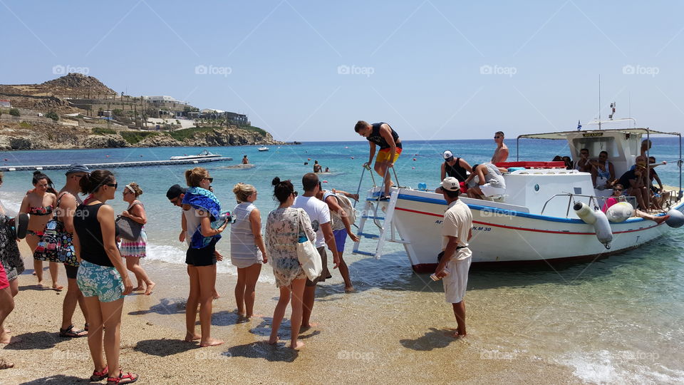 Boat to Paradise beach Mykonos. Small caique boat sailing from Paradise beach to Super Paradise at Cyclades 
Mykonos island Greece.