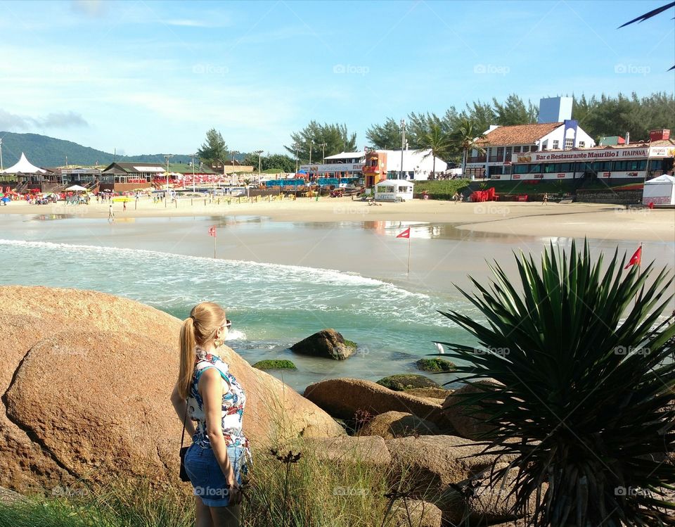 Girl observing the gorgeous beach from Florianópolis, Brazil