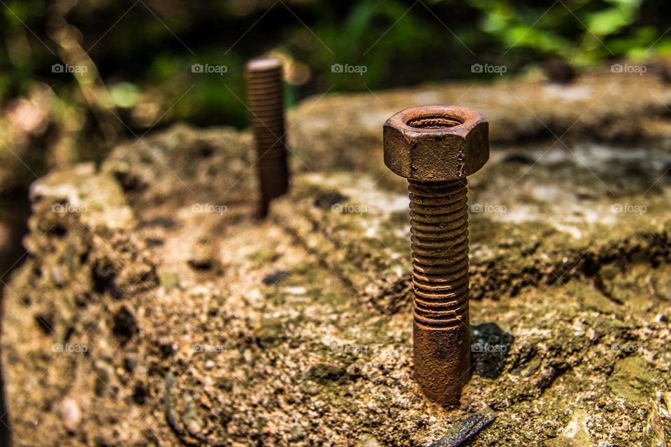 old rusted metal bolt and nut in concrete
