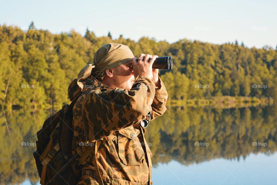 A man looks through binoculars