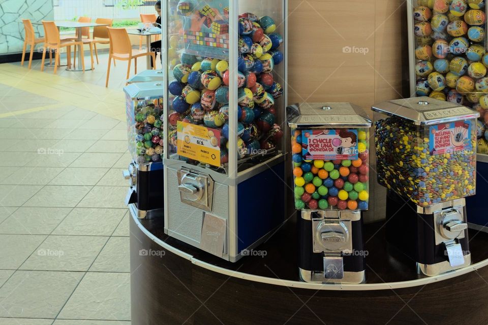 Colorful candies and chewing gum in dispenser for sale