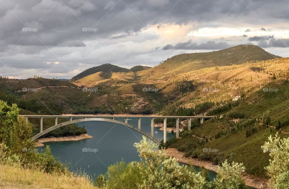 A view of Ponte da Pombeira crossing the Rio Zêzere and the surrounding mountainous landscape 