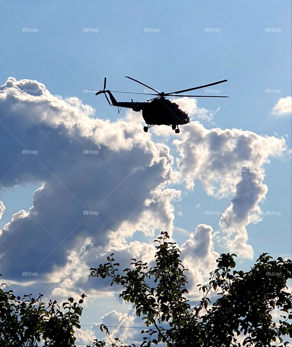 A silhouette of helicopter in the sky