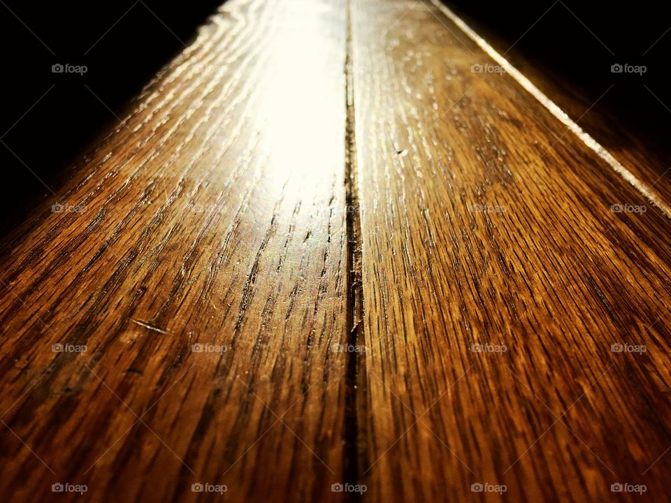 Perspective piece of light from the window spilling onto a wooden floor through a doorway