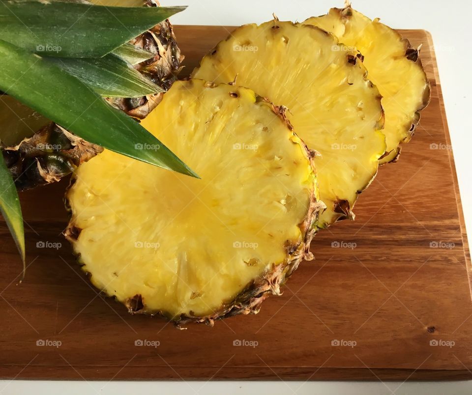 SweetJuicyFresh Pineapple/ on the cutting board. Bright colors make fruit more desirable.