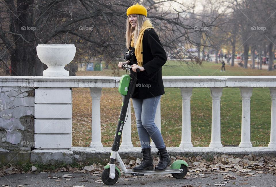 Young woman on the scooter in the park