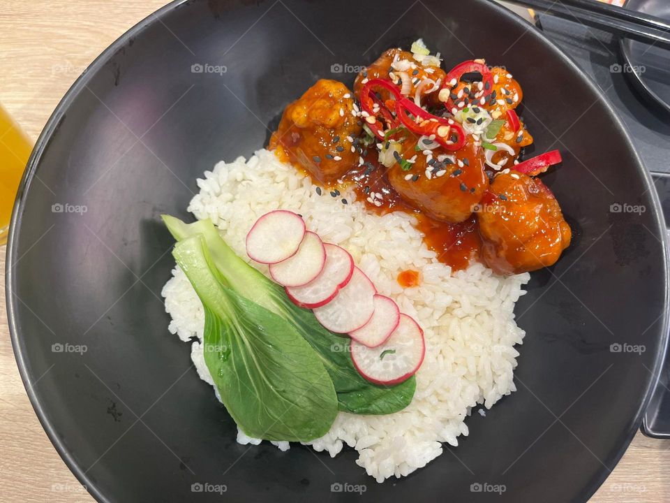 Capturing the beauty of food is as satisfying as enjoying it! This plate of rice, saucy chicken, and fresh veggies is a vibrant, flavorful creation perfectly balanced and delicious in every bite.