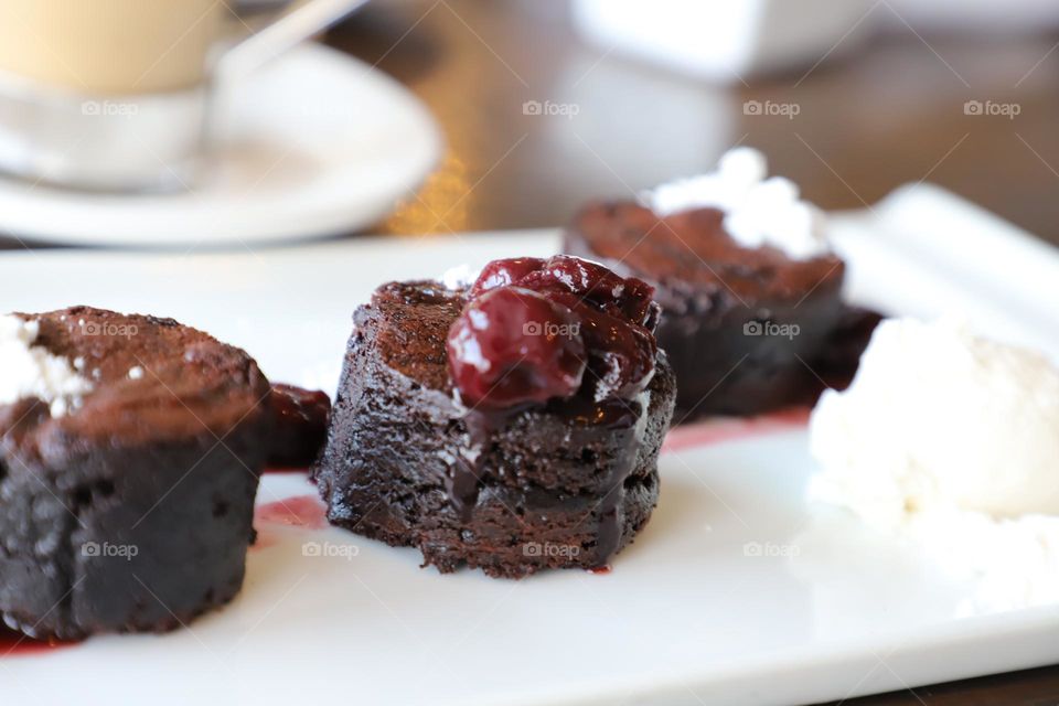 Cherry on top of brownies in a plate