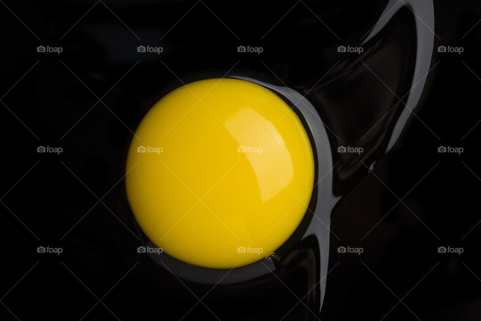 Yellow yolk on black background