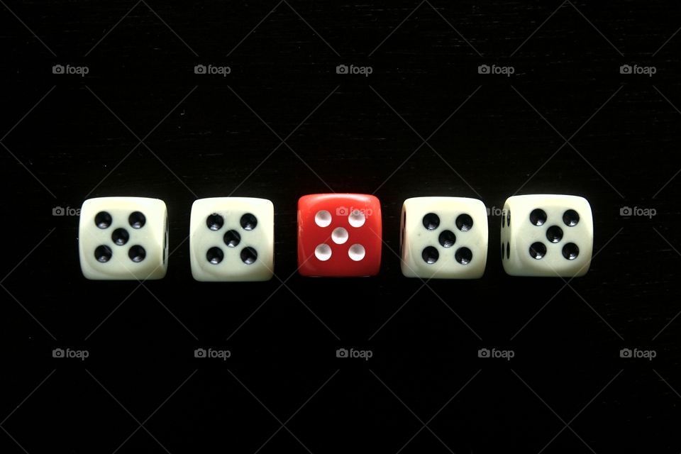 1 red dice among 4 white dice. photo of 1 red dice among 4 white dice