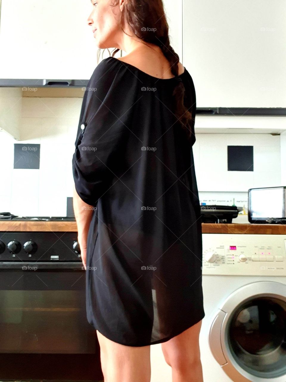 Woman in the kitchen. Photographed from the back.