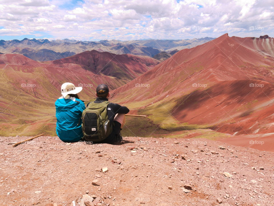 A couple watching over the red valley in Peru