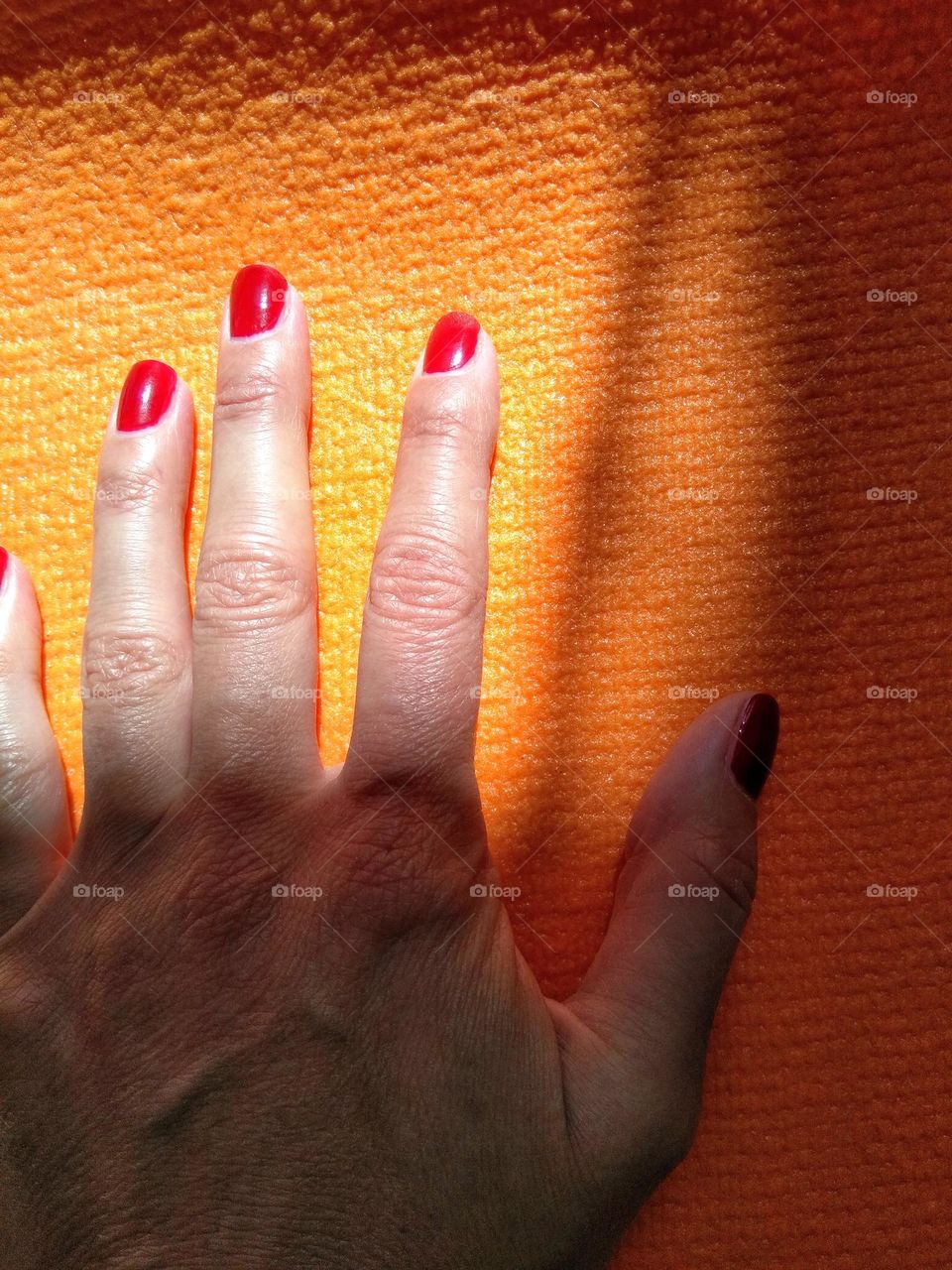 female hand on a orange mat background, sport lifestyle