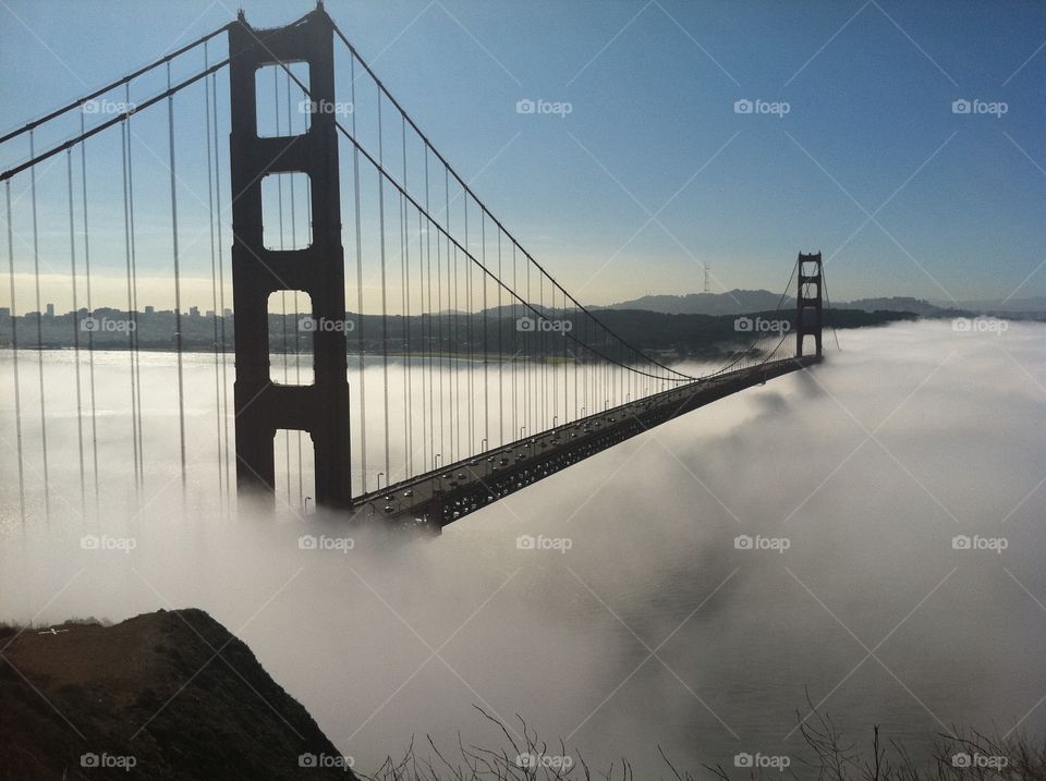 Foggy morning at the Golden Gate Bridge . The Golden Gate Bridge looks like it's coming out of the clouds. 