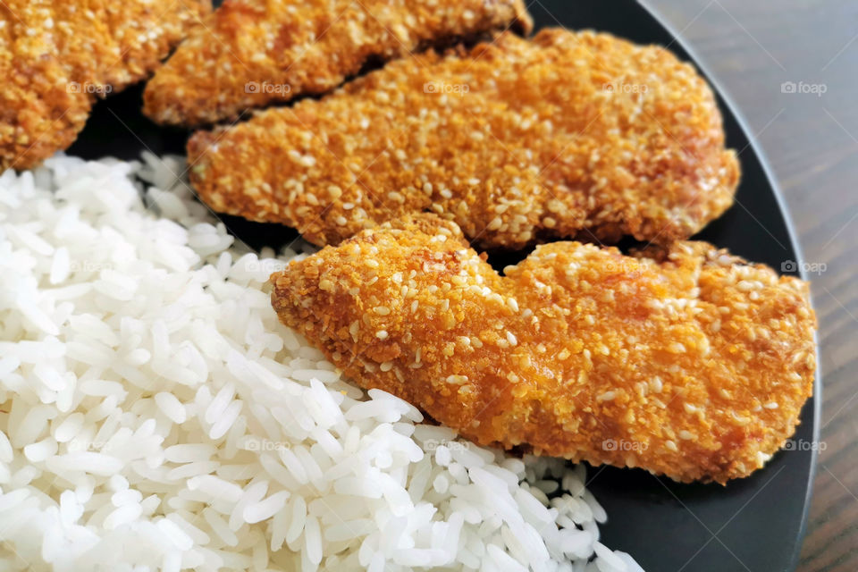 Crispy fried chicken with rice.  Selective focus.  Copy space is on the blurry part of photo.