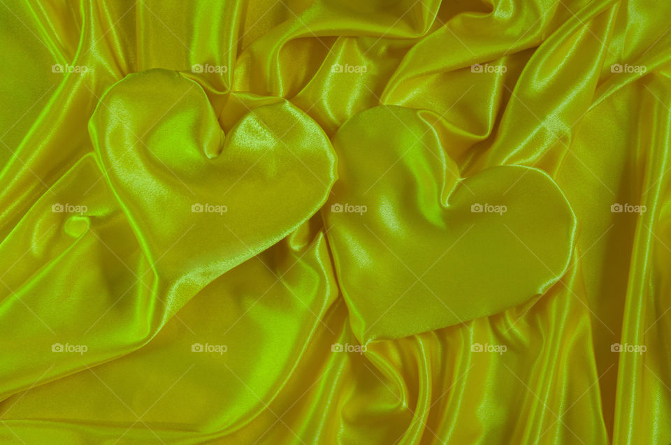 two hearts on a yellow satin fabric