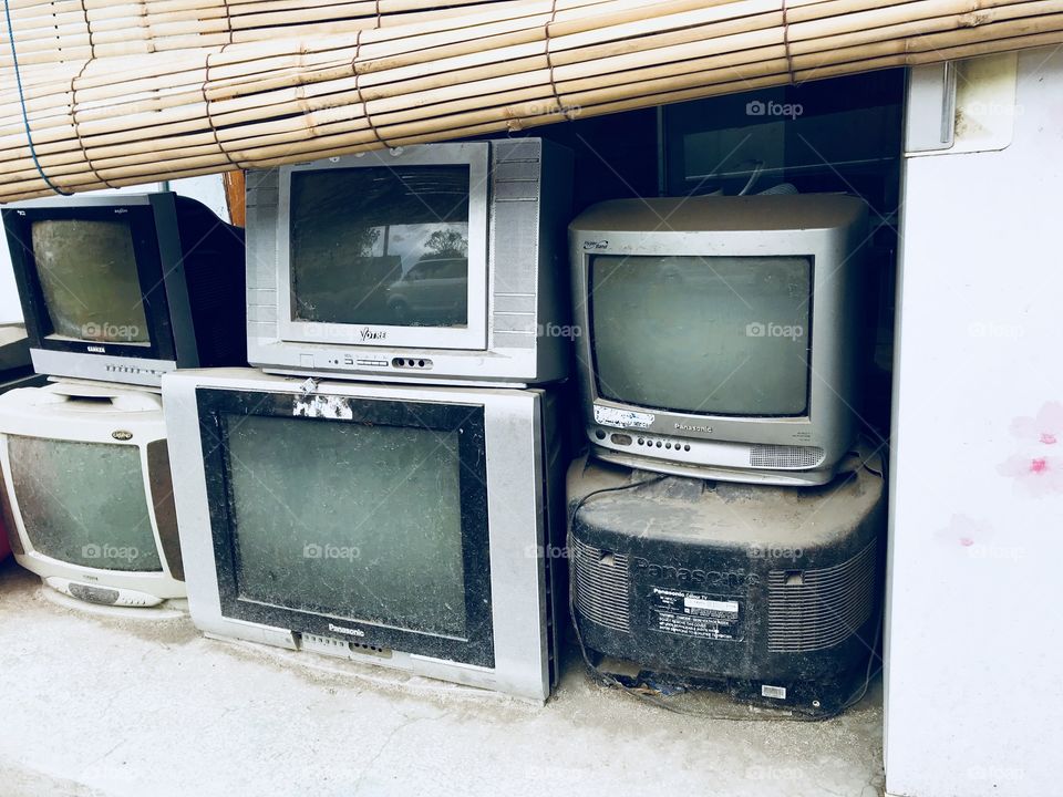 Old television piled outside 