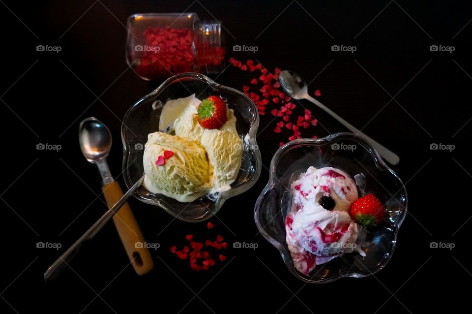 Ice cream on the table with a black background. Flat lay with forest fruit yoghurt and vanilla ice cream