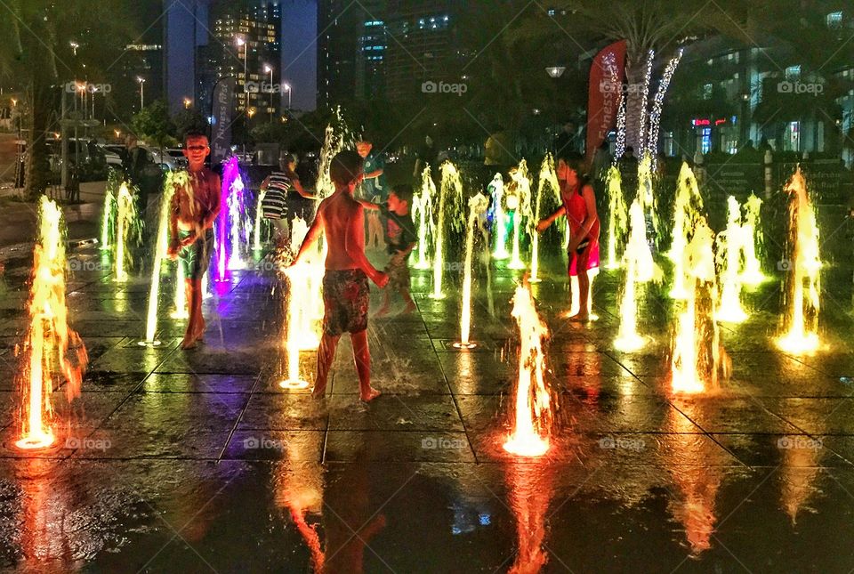 Children enjoying the colorful fountain 