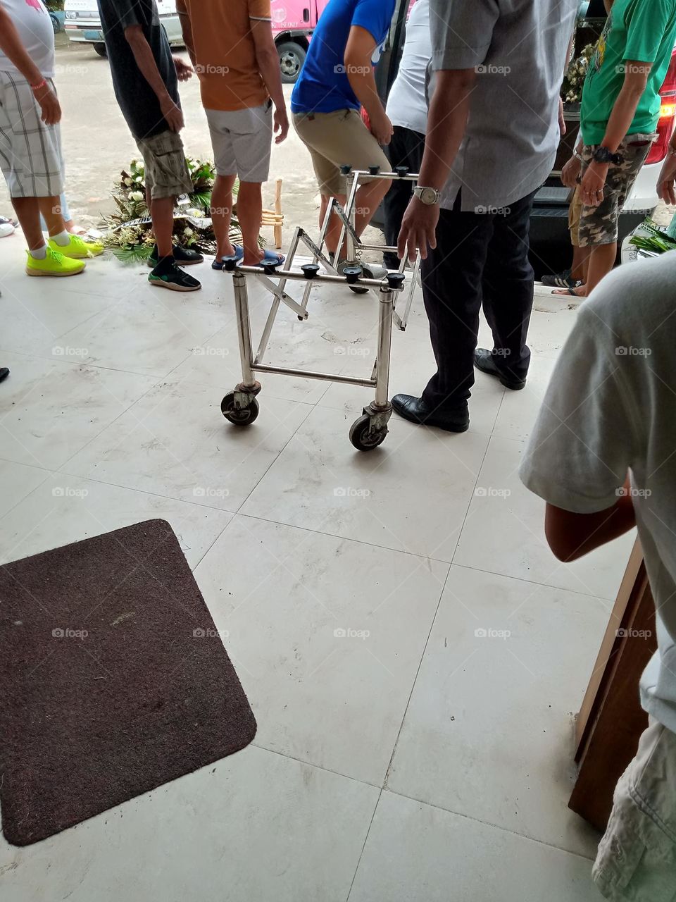 A COFFIN CARRIER IS READY FOR ITS PURPOSE,, TO TRANSPORT THE COFFIN FROM THE VEHICLE TO THE INSIDE OF THE CHURCH FOR THE HOLY MASS