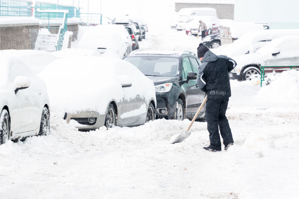 man removes snow with a shovel